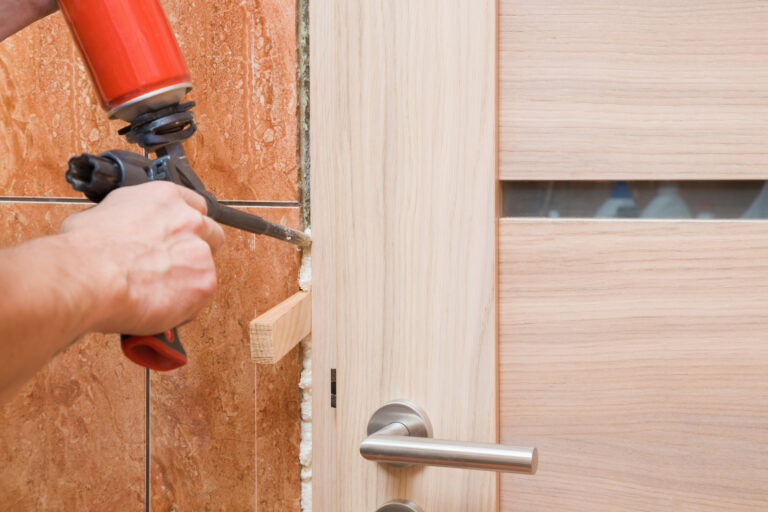Handwerker montiert Innentür mit Montageschaum – präziser Zargen und Türeinbau im Innenausbau.