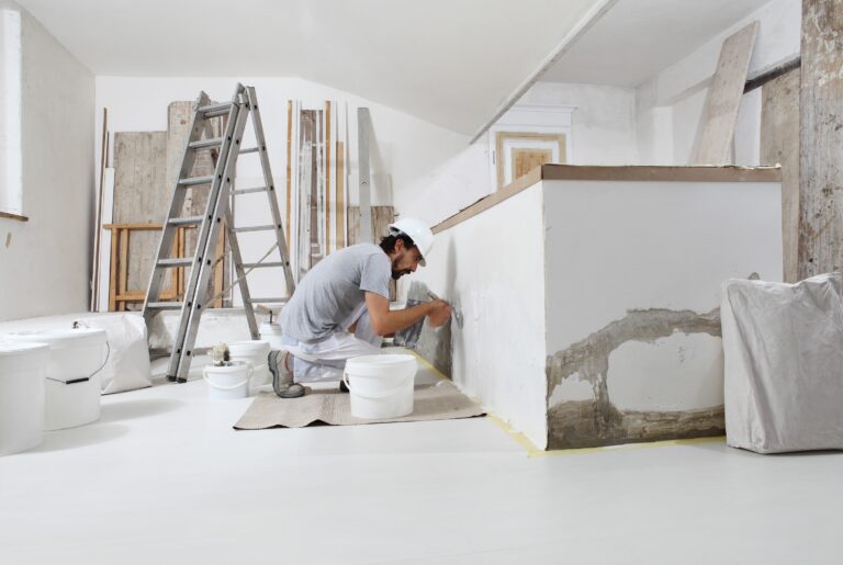 Handwerker verspachtelt Innenwand bei Renovierungsarbeiten - Trockenbau- und Malerarbeiten im Innenausbau.