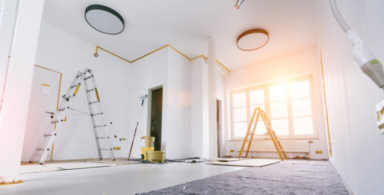 Renovierung im Innenausbau – frisch gestrichene Wände mit Leitern und Abdeckmaterial im Wohnraum.
