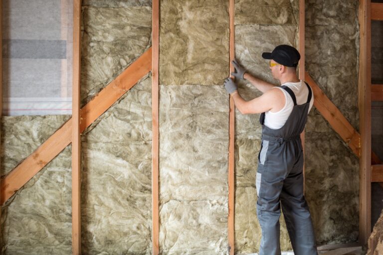 Handwerker installiert Dämmung an einer Wand für bessere Energieeffizienz.