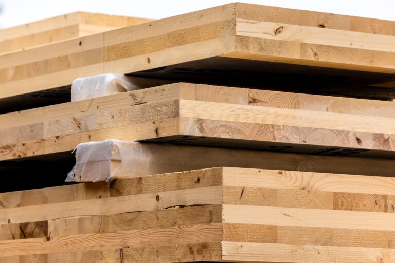 Mehrschichtige Brettsperrholzplatten (CLT) gestapelt – nachhaltiges Baumaterial im Holzbau.