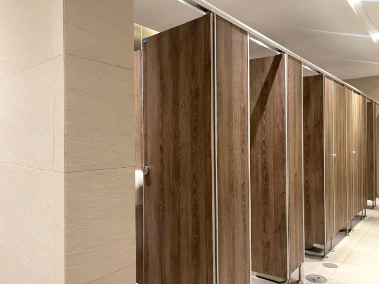 Öffentliche Toilettenanlage mit modernen WC-Kabinen in Holzoptik.