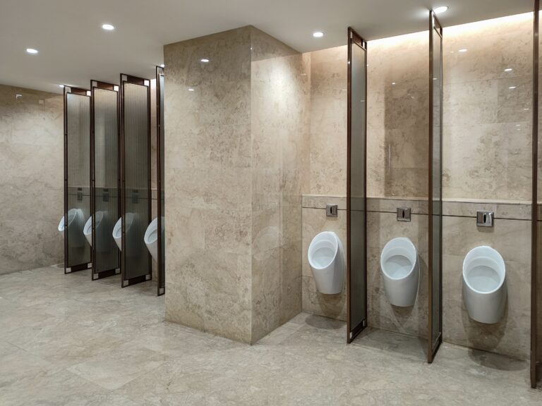 Moderne öffentliche Toilette mit Urinalen und Trennwänden – hygienische Sanitäreinrichtung und Sanitärtrennwände.